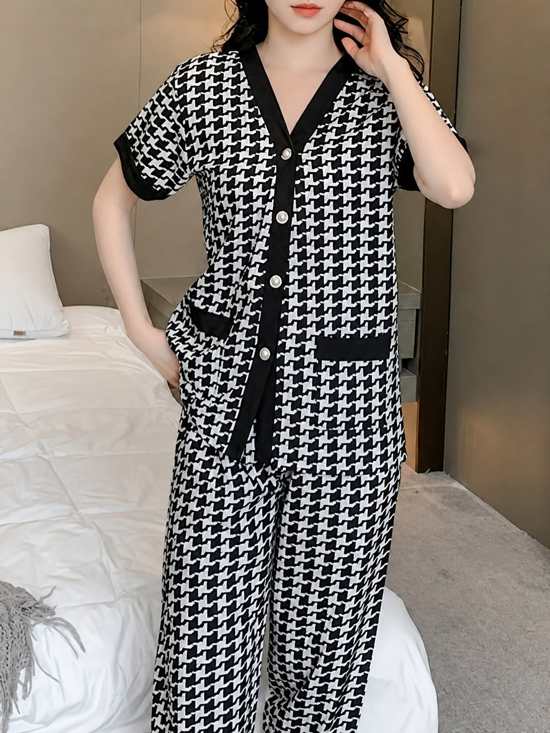 Person wearing a black and white patterned outfit in a bedroom setting